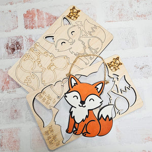 Wooden fox cutout with a hanging string on a textured white surface ready to be painted DIY Kits for kids
